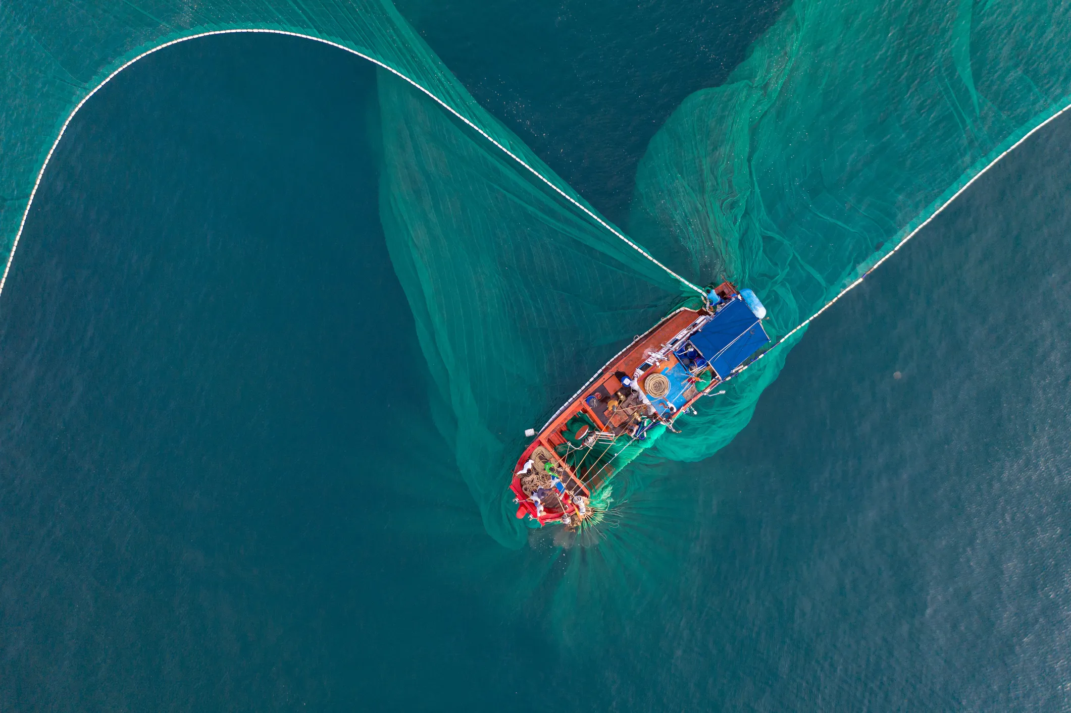 Aerial view of fishing boat casting its net in Vietnam sea.